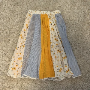 Fin kjol - Superfin kjol med blommigt och randigt mönster i vitt, gult och blått. Kjolen har spetsdetaljer i nederkanten😽❤️❤️