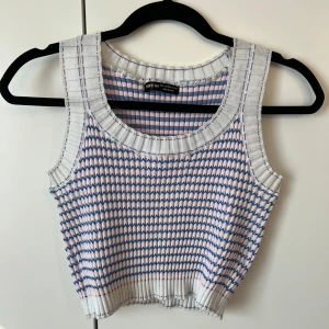 Ribbad croppad linnetopp från SHEIN - Säljer en ribbad croppad linnetopp från SHEIN i vitt med blå och rosa ränder. Toppen är ärmlös och har breda axelband samt rund halsringning. 