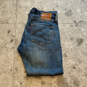 Levi's 501 blå jeansbyxor - Klassiska blå Levi's 501 jeans med raka ben. Väldigt snygga jeans enligt mig och är i helt ok skick. Nypriset ligger på cirka 1400 så ett väldigt bra pris.