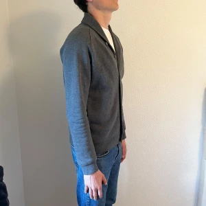 Grå cardigan från J.lindeberg - Säljer denna feta gråa cardigan från J.lindeberg. Skick 10/10. Pris 499kr. Vänligen skriv till mig ifall det finns frågor.
