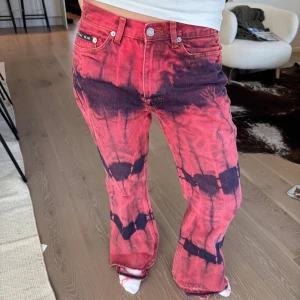 Rosa och mörklila jeans från BigBlue - Säljer ett par unika rosa jeans från BigBlue med mörklila batikmönster. Byxorna har klassisk femficksdesign och utsvängda ben. Storlek 36 och knappt använda! Säljer för att dem inte längre passar😊🩷