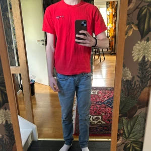 Röd t-shirt från Comme des Garçons Play - Röd t-shirt från Comme des Garçons Play med två broderade hjärtan på bröstet. Klassisk rund hals och korta ärmar. Perfekt för dig som gillar streetwear och vill sticka ut med en ikonisk detalj.