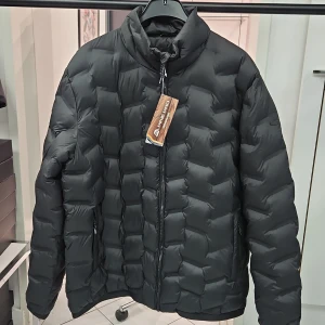 Svart dunjacka från Alpine Pro - Säljer en svart dunjacka från Alpine Pro i storlek XXL. Jackan har quiltad design, hög krage och dragkedja framtill samt vid fickorna. Perfekt för kyliga dagar och enkel att matcha med olika outfits.