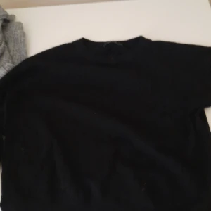 Svart stickad tröja - En enkel svart stickad tröja med rund halsringning. Perfekt basplagg som passar till det mesta och är lätt att matcha med andra kläder. Tröjan har långa ärmar och en klassisk passform.