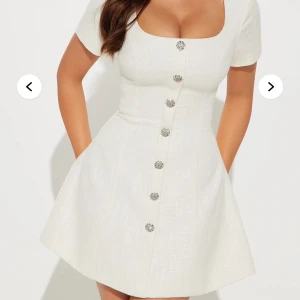 Vit kortklänning med knappar - Elegant vit kortklänning med markerad midja och utsvängd kjol. Perfekt för sommarens alla tillfällen. Det är i storlek S men sitter som M skulle jag säga. Säljer för att den är lite stor för mig. Prislappen sitter då den är aldrig använd 