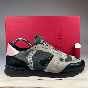 Valentino Rockrunner sneakers  - Säljer ett par Valentino Rockrunner sneakers med grått och svart camouflage-mönster. Skorna har detaljer i mocka och skinn, svart sula och en rosa detalj vid hälen. Med låda och allt. Pris kan diskuteras!