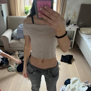 Beige offshoulder croppad topp - Säljer en beige offshoulder topp med ribbad struktur. Toppens modell är croppad och sitter tight. Perfekt för dig som vill ha en enkel men snygg topp till sommaren.