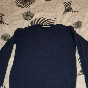 Mörkblå stickad tröja från D.M.D - Säljer en enkel och stilren mörkblå stickad tröja från D.M.D. Tröjan har rund halsringning och långa ärmar. Perfekt för lager-på-lager och passar till många olika outfits.