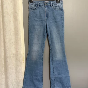 Blå bootcut jeans från ONLY - Säljer ett par klassiska blå bootcut jeans från ONLY. Jeansen har fem fickor, normal passform upptill och utsvängda ben. Perfekta för dig som gillar en retroinspirerad look. Stängs med knapp och dragkedja.