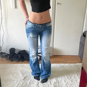 lowwaist bootcut jeans med slitningar - midjemåttet är 41cm och innerbenslängden är 82cm!🩷Crazy age liknande uperlågmidjade jeans från blue queen med slitningar och rosa detaljer på fickan! De är lagade på baksidan men tycker inte att man tänker på det när man har på sig jeansen även några rhinestones som gått bort från fickorna🩷Skriv för mått eller fler frågor! Accepterar förmodligen bud