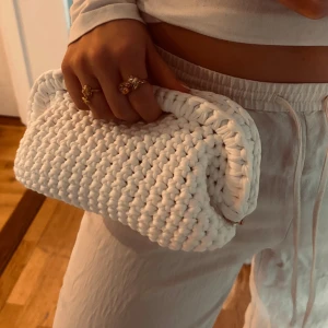 Vit handvirkad clutch / väska  - Säljer en vit handvirkad clutch / handväska som jag har virkat! Väskan är i ett mjukt garn och är väldigt rymlig! Kan bäras i handen som en clutch eller bäras i handtaget.  Kan Även Göra Andra Färger / storlekar💕 skriv för mått, olika på vissa 💕