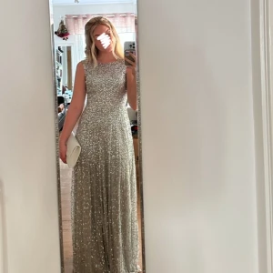 Balklänning! - Säljer nu min fantastiska balklänning!✨💫🪩💃Den är silver glittrig med en beige-aktig underklänning🪩🪩 Den har det mest magiska fallet och har bara använts en gång!🥰 Jag sydde in den själv i ryggen för att få en öppen rygg (se bild 3), men den går att sy ut för att dragkedjan ska gå ända upp!🩷