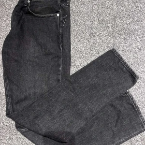 Svarta jeans från Calvin Klein Jeans - Säljer ett par svarta jeans från Calvin Klein Jeans med klassisk femficksdesign och raka ben. Jeansen har normal passform och är tillverkade i ett mjukt denimtyg. 