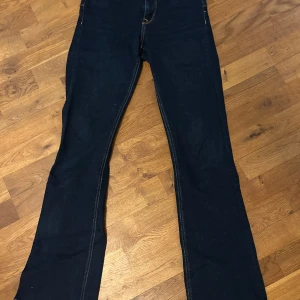 Mörkblå bootcut jeans - Säljer ett par mörkblå jeans med bootcut passform och medelhög midja. Skriv vid funderin om passform!