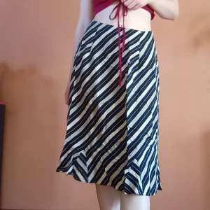 Svartvit randig kjol - Svartvit kjol med diagonala ränder. Kjolen har en A-linjeformad siluett och lite volangad nertill. Köpt på second hand och har sytt in den till storlek 38. Slutar lite under knäna på mig som är 164 cm ☺️