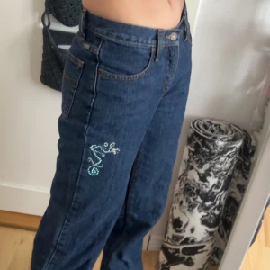 Y2K LOW-MID RISE Jeans-Cruel Girl🐉 - Säljer ett par blå jeans från Cruel Girl med baggy/relaxed fit. Byxorna har en unik detalj med en drake i strasstenar på benet och klassiska fickor både fram och bak