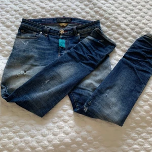 Blå jeans från Philipp Plein med små slitningar - Säljer ett par blå jeans från Philipp Plein med slitningar och tvättade detaljer. Byxorna har normal passform. Väldigt bra skick och väldigt snygga. Byxorna är 30/29 och passar rätt så bra oavsett mått.  PRIS KAN DISKUTERAS