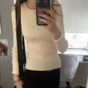 Vit ribbad långärmad tröja från H&M - Säljer en vit ribbad långärmad tröja från H&M. Tröjan har en tight passform och är tillverkad i mjukt material som sitter skönt mot kroppen. Perfekt att styla med jeans eller kjol.