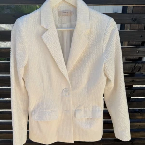 Kavaj vit  - Snygg vit kavaj i lite bäckebölja tyg. storlek 34. Knappt använd