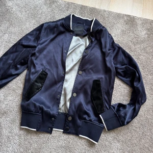 Limitato jacka - Snygg mörkblå bomberjacka från Limitato med svarta detaljer vid fickorna och vita kontrastkanter vid krage och muddar. 