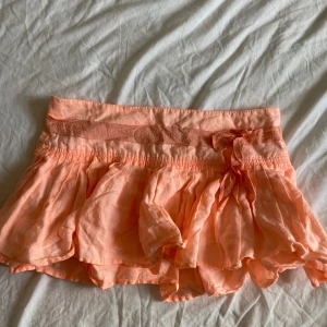 Lågmidjad minikjol - Superfin lågmidjad minikjol i en aprikos färg💕 har en rosett och en fin lapp bak💕 behöver strykas men annars i väldigt fint skick💕Dragkedja i sidan💕 storlek 10, skulle säga att den passar 36/38💕 midjemått- 40cm (väldigt lågmidjad). Längd- ca 28-30cm💕