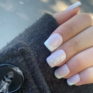 Summer nails  (FRENCH TIPS) (ALL SIZE -S-XL-)  - Snygga lösnaglar med klassisk fransk manikyr i vitt och ljusrosa. En nagel har en söt vit blomdesign som ger en extra touch. Naglarna är fyrkantiga och har en glansig finish. Perfekt för dig som vill ha en clean och stilren look med en twist. Om du är intresserad eller har några funderingar är du välkommen att meddela mig!😻🫶