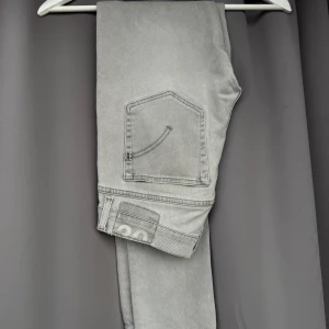 Dondup george jeans - Snygga grå jeans från Dondup i modell george. Storlek 30, bra skick! Snygg detalj på ena låret (se sista bilden)