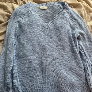 Ljusblå stickad tröja från Isay - Ljusblå stickad tröja från Isay i en melerad nyans. Tröjan har v-ringning och är tillverkad i en mjuk blandning av akryl och nylon. Perfekt för dig som gillar en avslappnad och stilren look.