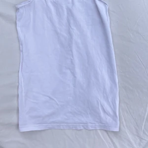 Vit linnetopp från H&M - Enkel och stilren vit linnetopp från H&M med tunna axelband. Toppen är rak i modellen och gjord i mjuk bomull, perfekt för varma dagar. Passar dig som gillar en clean och basic look.