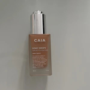 CAIA Dewy Drops Serum Foundation - CAIA Dewy Drops Serum Foundation i en snygg glasflaska med silvrig pump. Ger en fräsch, daggig finish och innehåller vitamin E och glycerin för återfuktning. Perfekt för dig som vill ha en naturlig, glowig bas. Säljer pga för mörk för mig, använd två gånger. 30W! 