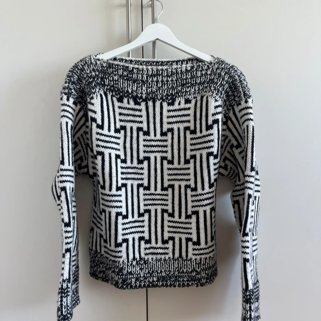 Svartvit stickad tröja med grafiskt mönster