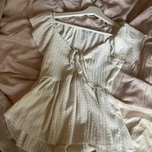 Vit sommarblus - Supersöt vit blus med volangkant och knyt framtill. Perfekt sommartopp