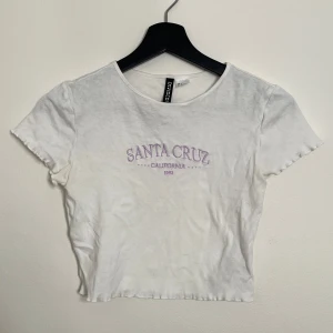 T-shirt crop top med lila broderi - Baby tee / Magtröja i bra skick 