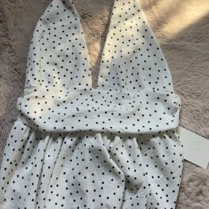 Vit prickig topp från Zara - Halterneck topp fårn Zara, andrig använd med prislapp på, trendig och snygg, storlek L men sitter som en S 
