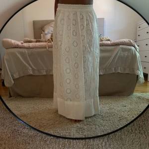 Vit broderad långkjol från Zara - Superfin vit långkjol från Zara med broderade blommor och elastisk midja. Perfekt nu till sommaren! Den köpt förra sommar men aldrig använd. Jag är 160cm lång för referens till längden. 