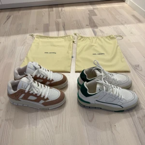 Axel Arigato - Hej! Jag säljer två par helt oanvända (endast testade) Axel Arigato ’Area lo’.  Nypris: 3450:-  Mitt pris: 1800:- /st eller 3400:- för BÅDA  (Vita skon har två små streck framtill och lite tyg genom på baksidan)