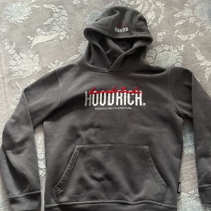 Grå Hoodie från Hoodrich med tryck - Snygg grå hoodie från Hoodrich med vit och röd logga framtill och tryck på ryggen. Tröjan har huva, magficka och långa ärmar. Perfekt streetwear-vibe och riktigt skön med mjukt material på insidan.