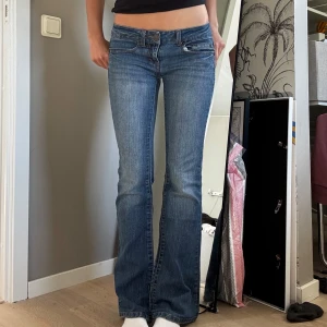 Blå bootcut jeans från So - Snygga blå bootcut jeans från So med klassisk femficksdesign och kontrastsömmar. Jeansen har låg midja och lätt utsvängda ben, perfekt för en avslappnad men trendig look. Tillverkade i mjukt denim med en skön passform.