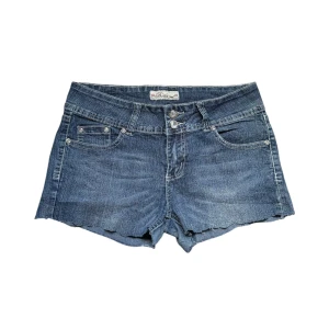 Jeansshorts med broderade bakfickor - Snygga blå jeansshorts med rå kant nertill och dubbla knappar framtill. Midjemått rakt över 38cm. Paljetter/pärlor har lossnat/ sitter löst. Kontakta vid intresse! 