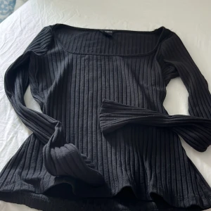 Svart ribbad långärmad tröja Lindex - Säljer en svart ribbad långärmad tröja från Lindex i storlek XS. Tröjan har en fyrkantig urringning och är figurnära med stretchigt material. Perfekt att styla med jeans eller kjol för en clean look.