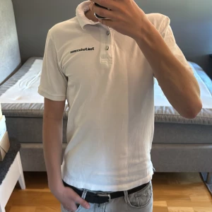 Vit pikétröja Peak Performance S - Klassisk vit pikétröja från Peak Performance i storlek S. Tröjan har korta ärmar, krage och knäppning med tre knappar framtill. Broderad logga på bröstet. Tillverkad i mjuk bomull som känns skön mot huden.