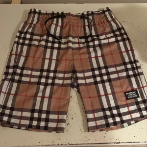 Rutig Burberry shorts - Ett par Burberry bad shorts i storlek xl men skulle säga de passar bättre som L, 10-10 i condition , bara att höra av sig för frågor 
