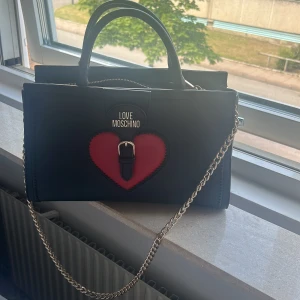 Moshino väska  - Köpt i Tyskland i köp center äkta man hittar inte just denna modellen så lätt men väldigtttt fin är den men säljer den för vill köpa en ny 