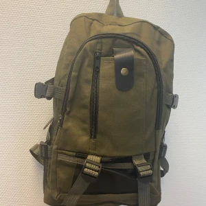 Trendig ryggsäck med många fack - Säljer en trendig ryggsäck med flera dragkedjefack, justerbara remmar och meshfickor på sidorna. Väskan har snygga spännen och detaljer i svart och mässing. Perfekt för dig som vill ha en praktisk och stilren väska till vardagen eller äventyret. Helt ny 