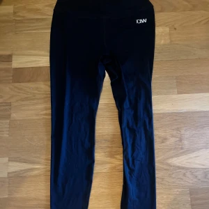 Svarta leggings från ICANIWILL - Svarta leggings från ICANIWILL med hög midja och scrunch-detalj bak. Snygg och tight passform, perfekta för träning eller chill. Tillverkade i stretchigt syntetmaterial som sitter skönt och följer kroppen.