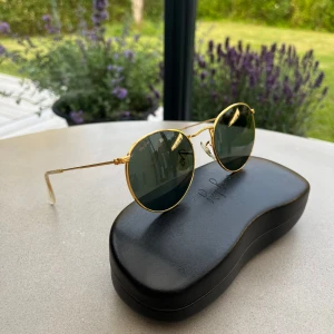 Ray-Ban solglasögon  - Coola Ray-Ban solglasögon från tidigt 90-tal. Nypris 1200kr. Endast små defekter på bågen, därav priset. Kommer med originalförpackning. Pris kan diskuteras.