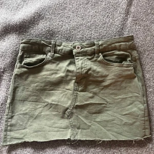 Olivgrön jeanskjol från ONLY - Olivgrön kort jeanskjol från ONLY med rå kant nertill. (Är i storlek M men är tight så passar som XS/S också) 