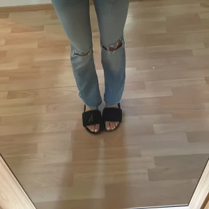 Ljusblå ripped jeans från Nelly - JAG BYTER TILL STORLEK 34 ELLER SÄLJER.   Säljer ett par ljusblå jeans från Nelly med snygga slitningar över knäna. Modellen har hög midja och raka ben med en lätt bootcut-känsla. Jeansen är i klassisk denim och har fem fickor samt dragkedja och knapp framtill.