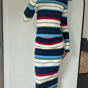 Randigt set från By Malene Birger - Snyggt set från By Malene Birger i stickad kvalitet. Setet har färgglada ränder i blått, rött, grönt, vitt och marinblått. Långärmad tröja och kjolen är i figurnära passform, perfekt för dig som gillar färg och mönster. Materialmix med viskos och bomull. Toppen är XXS och kjolen i S, funkar på mig som normalt bär S💖