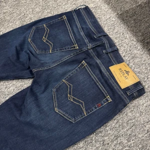 Replay Grover jeans mörkblå (Krobbes) - Mörkblå Replay Grover jeans med snygga kontrastsömmar och klassiska fem fickor. Jeansen har raka ben och normal passform, tillverkade i mjukt denimtyg. Märkespatch bak i midjan och diskreta Replay-detaljer vid fickorna. Bara använd två gånger av Krobbe, på två olika videos (finns på TT) så nästintill nya. Mycket bra skick! 899kr välmött, BB🍾